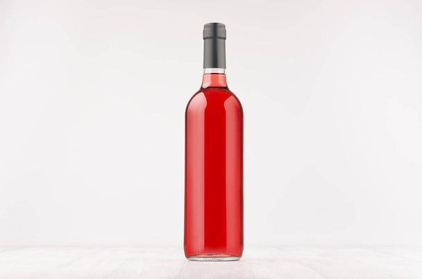 Wine bottle with rose wine on white wooden board, mock up.  - Photo, image