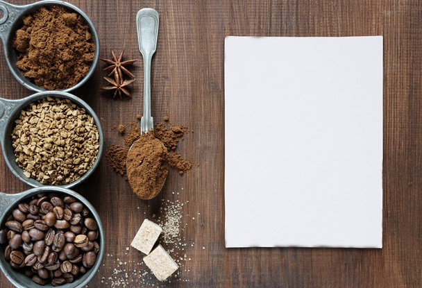 Different types of coffee and white card are on a wooden backgro - Photo, image