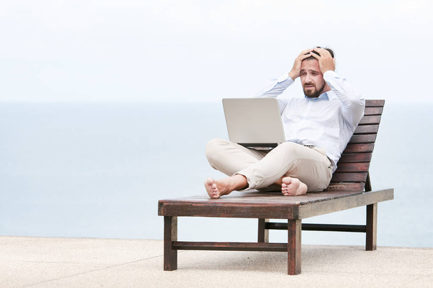 Businessman freelance on beach with laptop - Photo, image