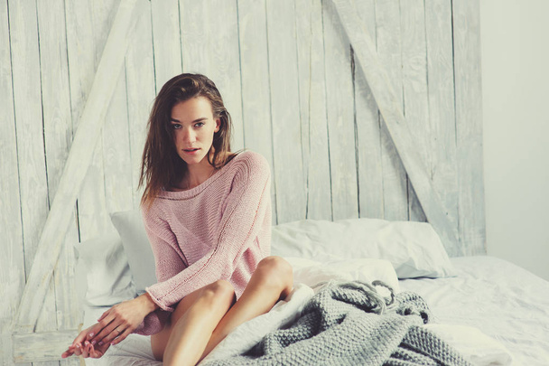 young sexy woman in pink lingerie relaxing at home in bed. Casual lifestyle in modern nordic interior - Foto, afbeelding