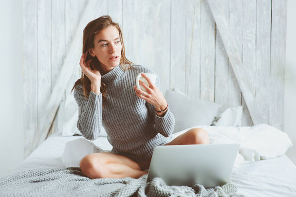young blogger or business woman working at home with social media, drinking coffee in early morning in bed. Modern living in scandinavian interior, casual lifestyle - Foto, Imagen