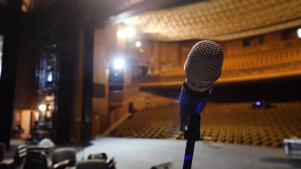 Microfone no palco e sala vazia durante o ensaio. Microfone no palco com luzes de palco no fundo. Microfone no palco no corredor vazio
 - Foto, Imagem