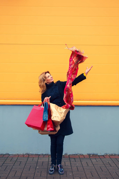 Beautiful woman with shopping bags looking at purchases.  - Foto, afbeelding