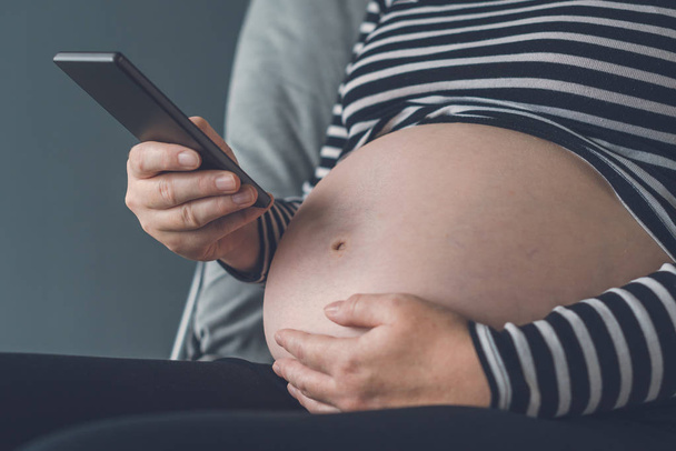 Pregnant woman using smartphone - Foto, Imagen