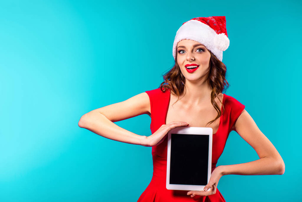 Frau im Weihnachtsmannkostüm präsentiert Tablet - Foto, Bild