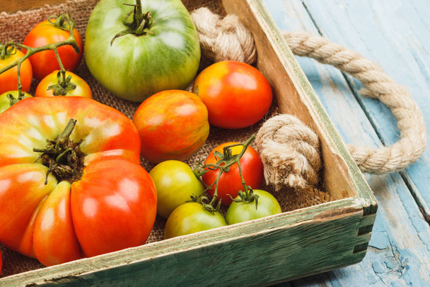Set of ripe tomatoes in the wooden tray - Foto, Bild