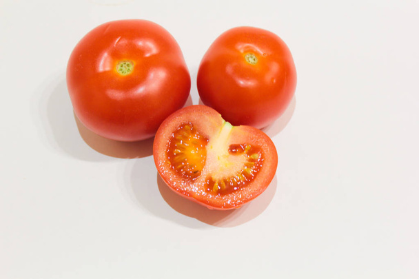 Red tomatoes on a white background, sliced tomatoes - Photo, Image