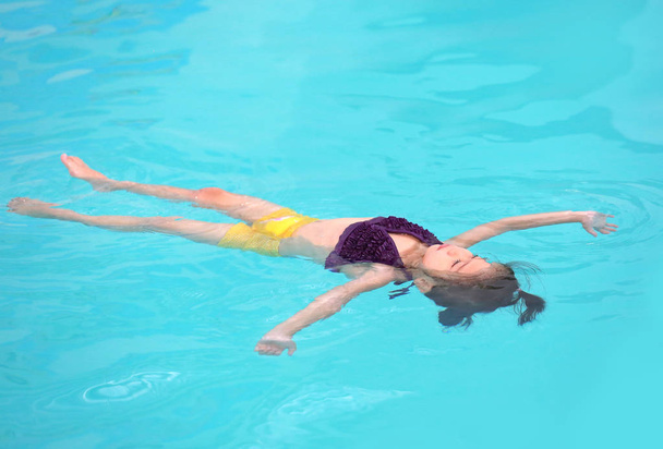 Portrait of little girl in swimming pool - Foto, afbeelding