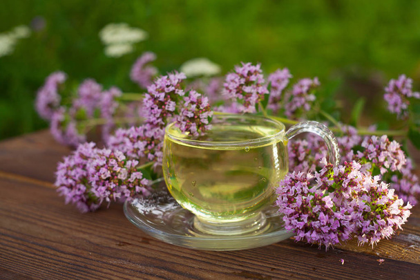 délicieux thé d'origan dans un beau bol en verre sur la table
 - Photo, image