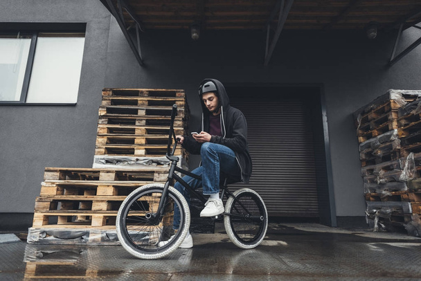 BMX cyklista pomocí smartphonu    - Fotografie, Obrázek