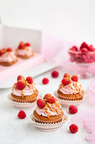 Raspberry and caramel cupcakes on white background - Photo, Image