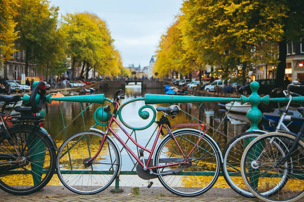 Canal in the center of the city at sunset. Bicycles standing on the bridge with an amazing Amsterdam view. - Φωτογραφία, εικόνα