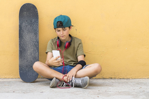 Retrato de un adolescente sentado en el suelo en una calle cha carretera
 - Foto, imagen