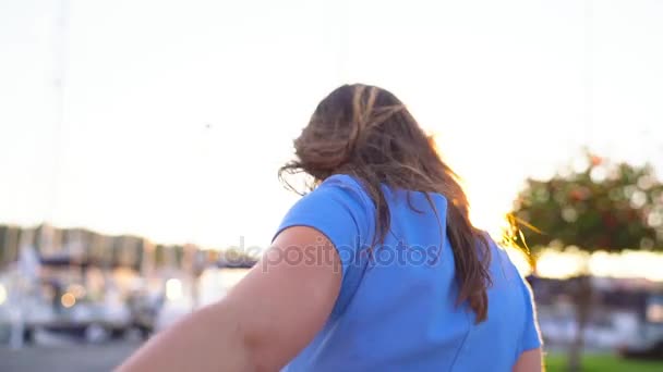 Follow me - happy young woman in sunglasses pulling guys hand. Hand in hand walking to the marina with a lot of yachts and boats, close up - Footage, Video