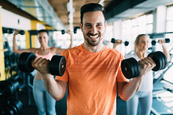  attractive man doing exercises in gym - Photo, Image