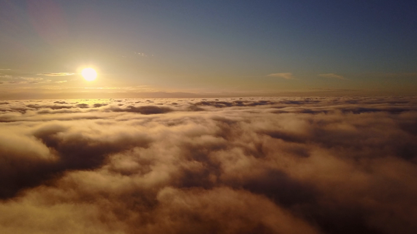 Bulutların arasından yükselen gökyüzü ve gün batımı. Gün batımı sırasında bulutların üstünde uçan - Video, Çekim
