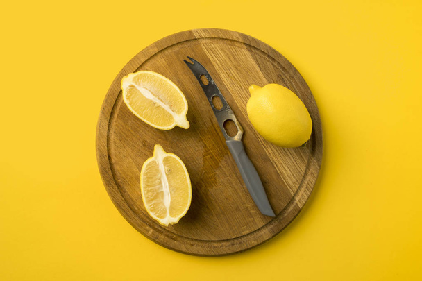 лимоны и нож на деревянной доске
 - Фото, изображение