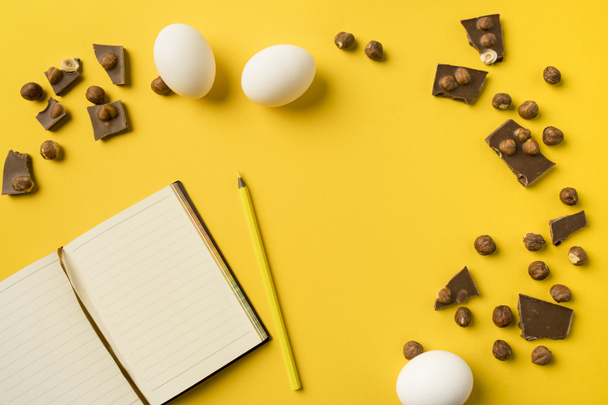 Jegyzetfüzet és ceruza, a csokoládé és a tojás - Fotó, kép