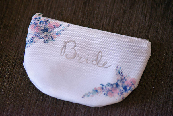 horizontale Aufnahme von Brautaccessoires, eine kleine, einfache Handtasche für das Wesentliche der Braut, Ideen, Konzepte für die morgendliche Vorbereitung der Braut.  - Foto, Bild