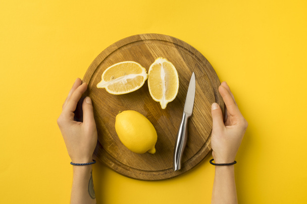 donna che tiene tavola di legno con limoni
 - Foto, immagini