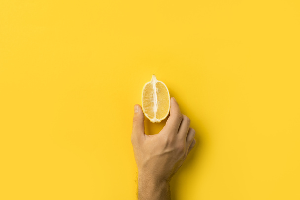 homem segurando metade de limão
 - Foto, Imagem