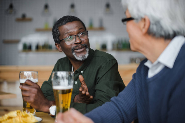 amigos mayores hablando y bebiendo cerveza
 - Foto, imagen