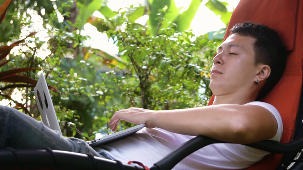 Unelmatyötä. Vakava mies työskentelee trooppisessa paikassa, makaa riippumatossa. Onnellisin työ. Tiukka suunnitelma. Freelancerina. Hidastus
 - Materiaali, video