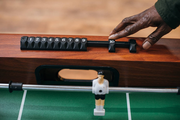man moving counter on table football - Photo, Image