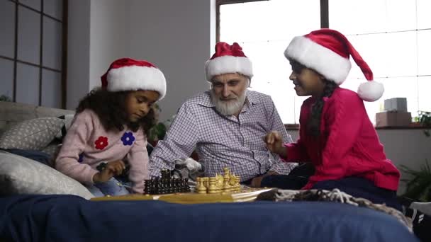 zwei Schwestern mit gemischter Rasse spielen an Heiligabend Schach - Filmmaterial, Video