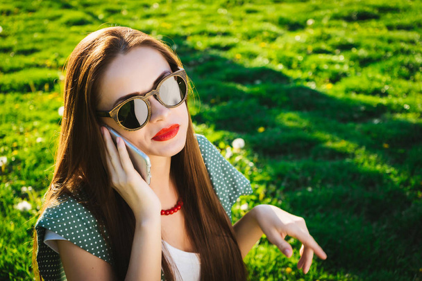 Irritated woman with smartphone.Annoyed angry face in sunglasses - Foto, afbeelding