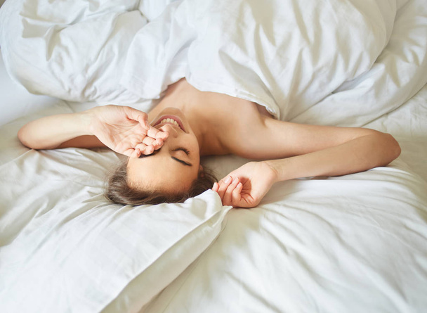 young woman lying on bed - Фото, изображение