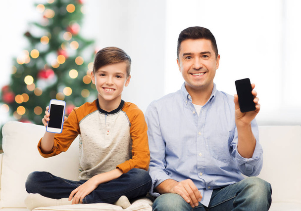 happy father and son with smartphones at christmas - Фото, изображение