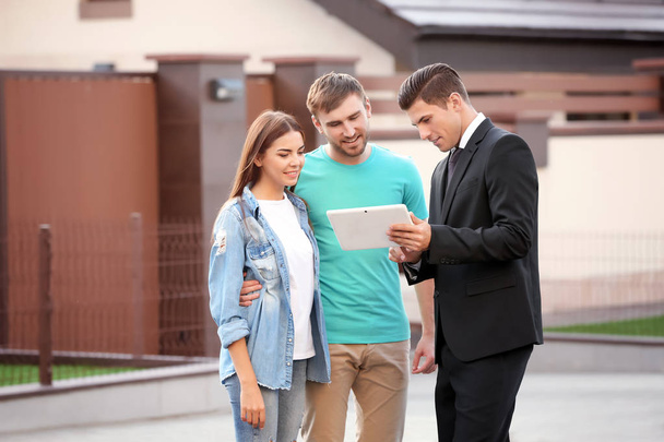 Young couple with real estate agent near house - Photo, image