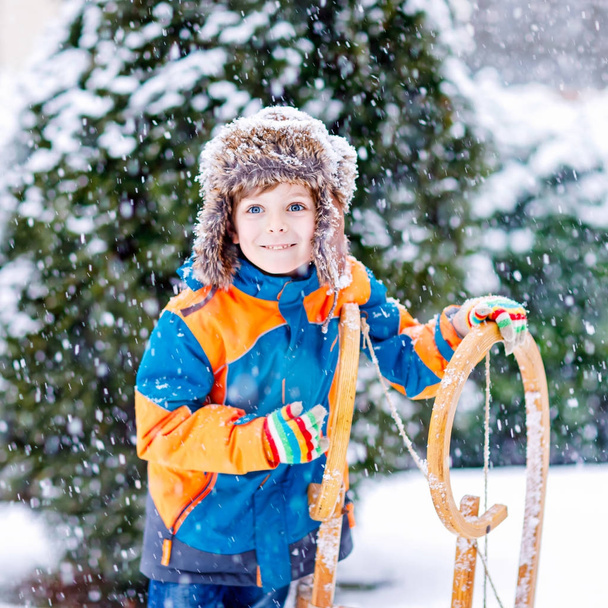 Niño pequeño disfrutando de paseo en trineo en invierno
 - Foto, Imagen