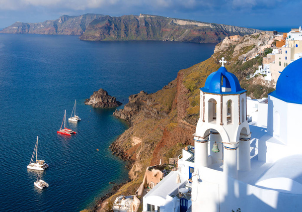 Ciudad de Oia en la isla de Santorini, Grecia. Casas e iglesias tradicionales y famosas con cúpulas azules sobre la Caldera, el mar Egeo - Foto, Imagen