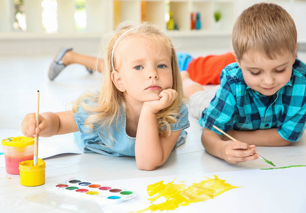Kinder liegen auf dem Boden im hellen Raum und malen - Foto, Bild