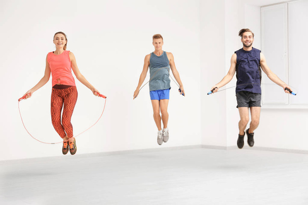 Young people in sportswear with jumping ropes indoors - Foto, Imagem