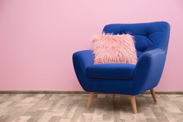 Blue armchair with pillow near wall - Zdjęcie, obraz