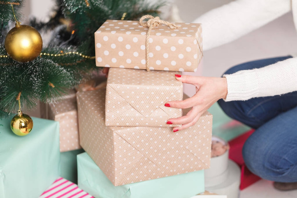 Poner regalos de Navidad bajo un árbol
 - Foto, Imagen