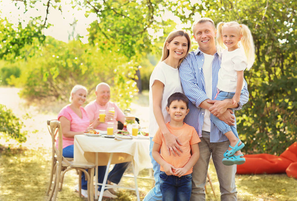 Щаслива сім'я проводить вечірку барбекю на відкритому повітрі
 - Фото, зображення