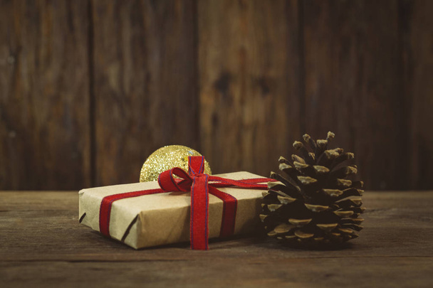 Новорічно-різдвяна концепція. Подарунок, ялиновий конус, золота куля на
 - Фото, зображення