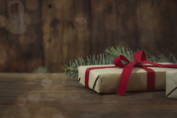Gift, fir branch on a wooden background. Bokeh - Zdjęcie, obraz