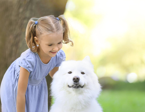 Cute little girl with dog in park - Fotoğraf, Görsel