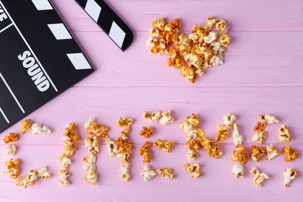 Movie clapper and word CINEMA made of caramel popcorn  - Photo, image