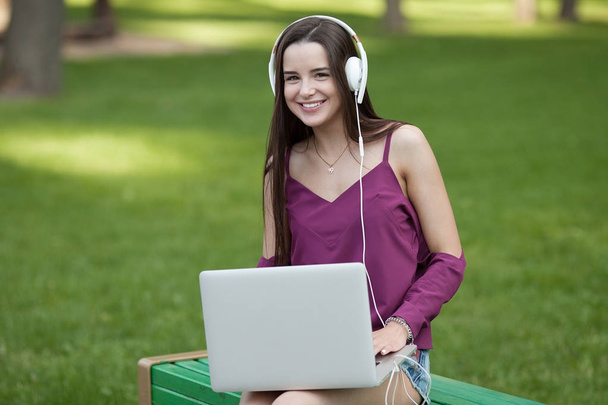Young adult using laptop outdoors - Фото, зображення