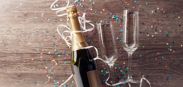 Photo of bottle of wine with two wine glasses, confetti - Foto, imagen