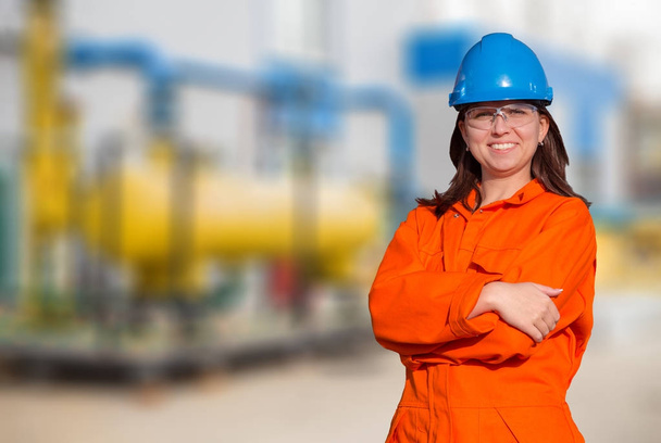 Mujer trabajadora en general naranja y casco de seguridad azul aislado sobre fondo blanco
 - Foto, imagen