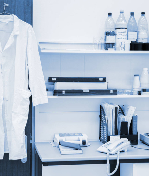 white robe hanging on a door in laboratory - Foto, Imagem