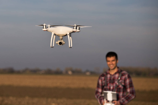 Contadino che naviga drone sopra terreni agricoli
 - Foto, immagini