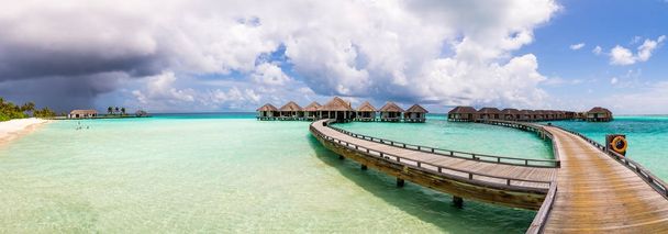 langer leerer Steg auf den Malediven mit Korallenriffen im Wasser. - Foto, Bild